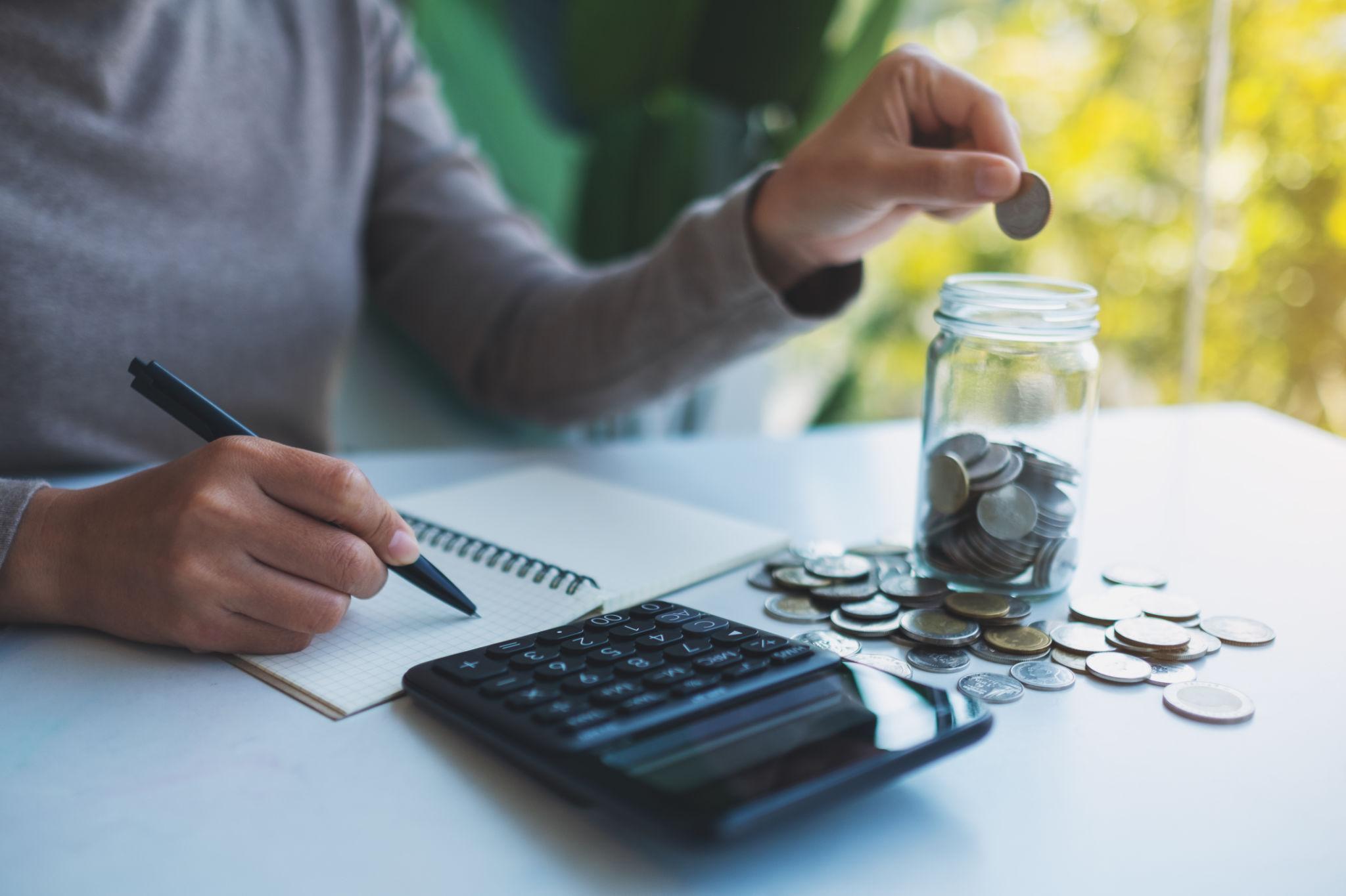 Sinking fund meaning explained with a savings jar and budgeting notebook